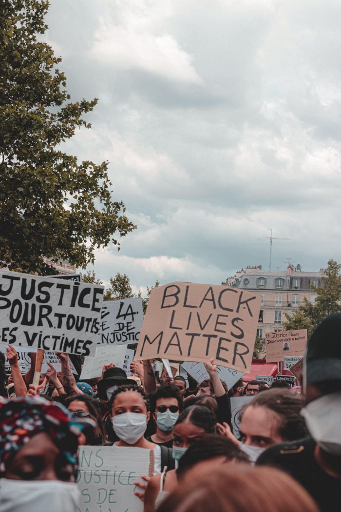 Young multiracial people in protective masks demonstrating  signs and standing on protest